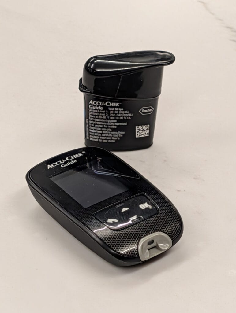 Accu-Chek Guide blood glucose meter by Roche with a vial of Accu-Chek Guide test strips