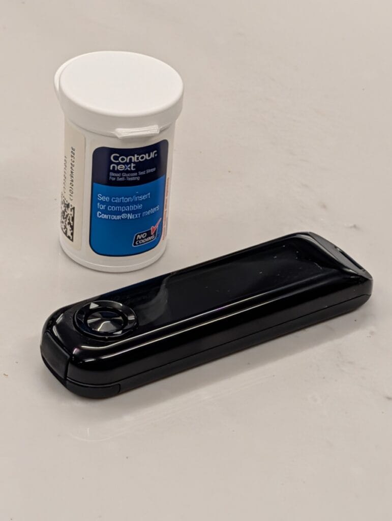 Contour Next One blood glucose meter with a vial of Contour Next test strips